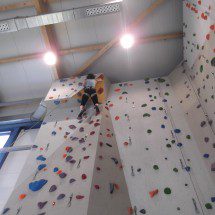 Frau klettert bis ganz oben an der Kletterwand in der Kletterhalle Donauwörth