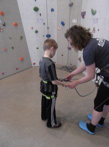 Kind wird mit Seilen in der Kletterhalle Donauwörth gesichert